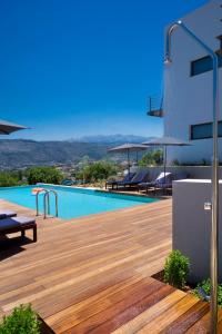 una piscina sul lato di un edificio con terrazza in legno di Seametry Apartments a Souda (Suda)