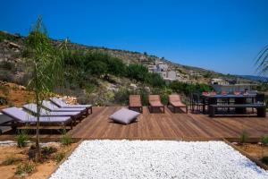 una terrazza in legno con sedie e un tavolo su una collina di Seametry Apartments a Souda (Suda)