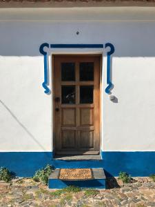 una puerta de madera en un edificio blanco y azul en Azeite de Marvão, Olivoturismo casa Mestre do Lagar, en Marvão