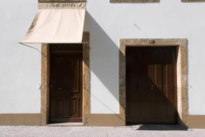 zwei Türen an der Seite eines Gebäudes in der Unterkunft Duas Portas Townhouse in Porto