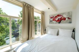 una camera con un letto e una grande finestra di The Blue Stairs ad Amsterdam