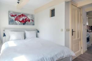 una camera bianca con letto bianco e cucina di The Blue Stairs ad Amsterdam