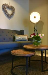 a living room with a couch and a table with a lamp at Hotel Stadt Aurich in Aurich