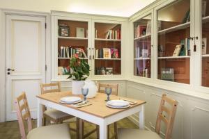 una sala da pranzo con tavolo, sedie e librerie di Suite della villa a Lecce