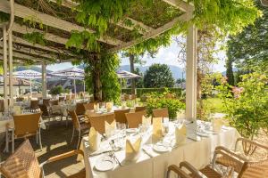 un ristorante con tavoli e sedie bianchi e viti di Hotel Schneeberghof a Puchberg am Schneeberg