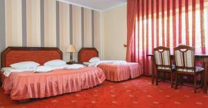 a hotel room with two beds and two chairs at Hotel Premier in Cluj-Napoca