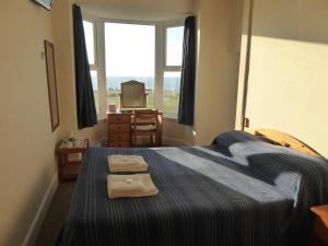 - une chambre avec un lit et 2 serviettes dans l'établissement Longbeach- Adults Only, à Newquay