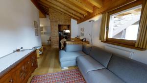 a living room with a blue couch and a window at Carla 12 in Sils Maria