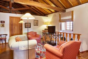 a living room with two chairs and a tv at Casa D Obidos in Óbidos