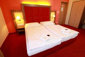 - une chambre avec un grand lit et 2 serviettes dans l'établissement Hotel U Divadla, à Znojmo