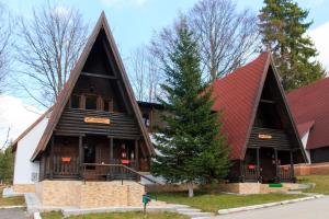 un grand bâtiment en bois avec un toit rouge dans l'établissement Centrul de Echitatie Poiana Brasov, à Poiana Brasov