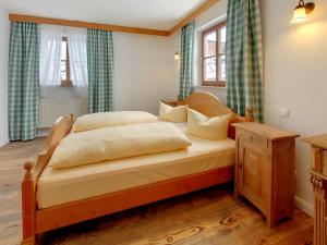 1 Schlafzimmer mit einem Holzbett und 2 Fenstern in der Unterkunft Gasthof Ochsenwirt in Oberaudorf