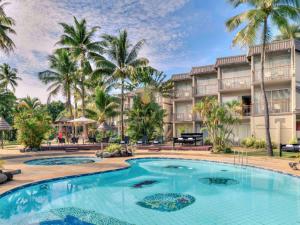 einen Pool vor einem Resort mit Palmen in der Unterkunft Mercure Nadi in Nadi