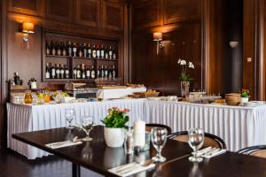 a restaurant with two tables and a counter with wine glasses at Hotel Kašperk in Kašperské Hory