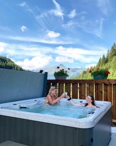 twee vrouwen in een jacuzzi met uitzicht bij Chalet Bluebell in Les Gets