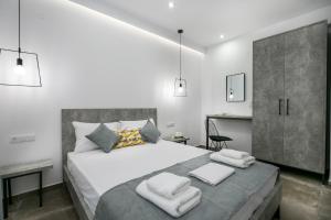 1 dormitorio con 1 cama grande y toallas. en Il Grigio Apartments, en Limenaria