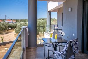 balcón con mesa, sillas y vistas en Il Grigio Apartments, en Limenaria