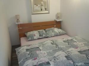 een slaapkamer met een bed met een dekbed erop bij Studio apartman Toplica in Daruvar