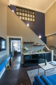 a living room with a blue couch and a staircase at The Goodwin in Hartford