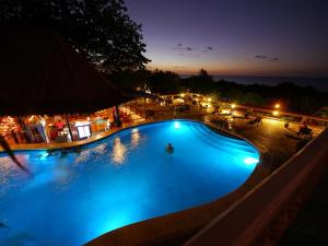 een groot zwembad met blauwe verlichting in de nacht bij Best Western Tamarindo Vista Villas in Tamarindo