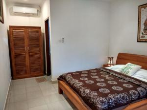 una camera da letto con un letto con una coperta marrone di Batik Sekar Bali Guest House ad Ubud