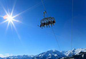 eine Gruppe von Menschen auf einem Skilift in den Bergen in der Unterkunft Berghotel Blaickner's Sonnalm in Zell am See