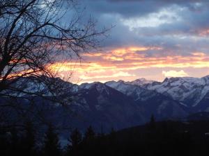 einen Sonnenuntergang über einer Bergkette mit schneebedeckten Bergen in der Unterkunft Berghotel Blaickner's Sonnalm in Zell am See