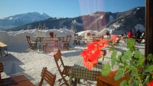 eine Gruppe von Tischen und Stühlen im Schnee in der Unterkunft Berghotel Blaickner's Sonnalm in Zell am See