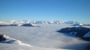 Aussicht auf schneebedeckte Berge von oberhalb der Wolken in der Unterkunft Berghotel Blaickner's Sonnalm in Zell am See