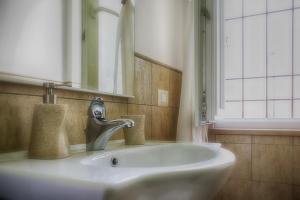 a bathroom sink with a faucet and a mirror at La Dolce Casetta in Grottaferrata