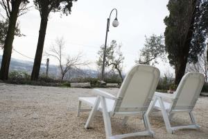 two white chairs sitting next to a street light at La Dolce Casetta in Grottaferrata