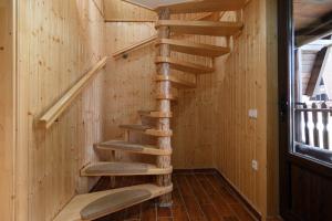 - un escalier en bois en colimaçon dans une maison en bois dans l'établissement Centrul de Echitatie Poiana Brasov, à Poiana Brasov