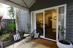 eine Terrasse mit 2 Stühlen und einem Tisch in der Unterkunft Clement House in Benalla