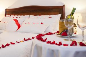 un letto con rose rosse su un tavolo con una bottiglia di vino di Hotel Embassy Park a Bogotá