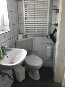 een badkamer met een wit toilet en een wastafel bij Haus Heverstrom in Westerhever