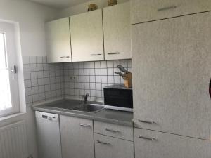 een keuken met een wastafel en een magnetron bij Haus Heverstrom in Westerhever