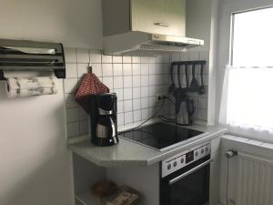 een keuken met een wastafel en een fornuis top oven bij Haus Heverstrom in Westerhever