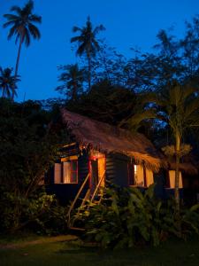 珍南海滩Bon Ton Antique Wooden Villas的一间小屋,晚上有茅草屋顶