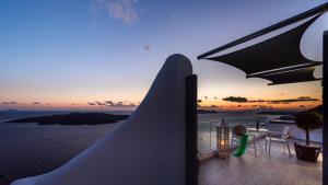 - un balcon avec vue sur l'océan au coucher du soleil dans l'établissement Fira Deep Blue Suites, à Fira