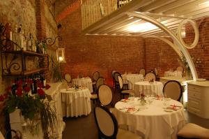 een eetkamer met witte tafels en stoelen met rozen bij Hotel Cascina Di Corte in Venaria Reale