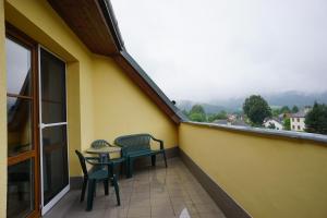 a balcony with two chairs and a table at Apartmá Kateřina Velké Losiny in Velké Losiny