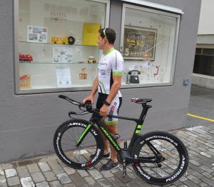 Ein Mann, der ein Fahrrad vor einem Laden hält. in der Unterkunft Central Hotel Post in Chur