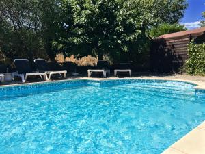 einen Pool mit Stühlen und einem Pool in der Unterkunft Hotel Les Oliviers in Draguignan