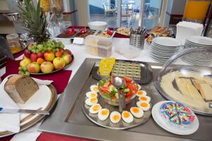 una tavola con buffet di cibi con uova e frutta di Hotel Trend a Plzeň