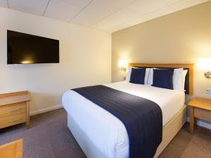 a hotel room with a large bed and a tv at Haven Hotel in Poole