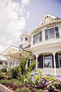 une maison blanche avec des fleurs devant elle dans l'établissement Castle Hill Inn, à Newport