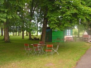 une table et des chaises sous un arbre dans une cour dans l'établissement Hotel Sternen, à Lenzkirch