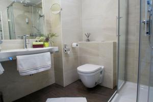 a bathroom with a toilet and a sink and a shower at College Garden Hotel in Bad Vöslau