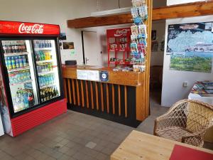 eine Cola-Kühlbox in einem Laden mit einer Theke in der Unterkunft Camping Intercamp Tatranec in Tatranská Lomnica