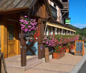 ル・ホーヴァルトにあるLogis Hôtel Restaurant La Petite Auberge Alsaceの花の横の建物